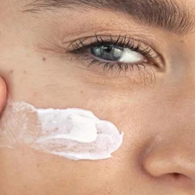 Close-up of a person applying cream to their face